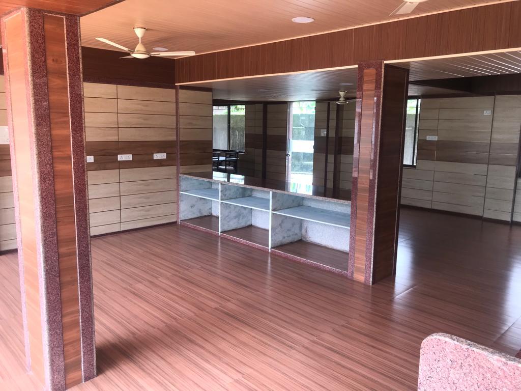 Spacious wood-panelled auditorium hall with pillars and polished flooring