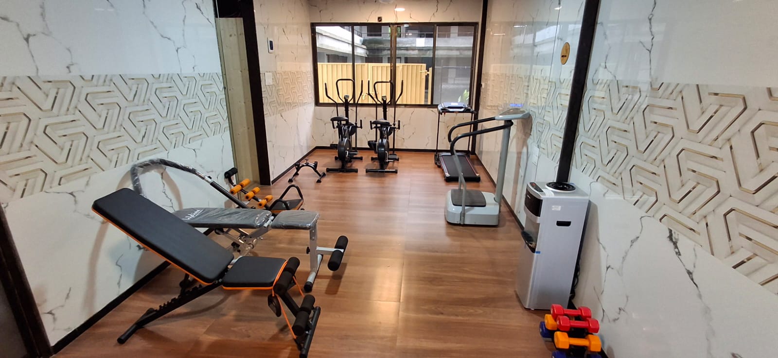 Air-conditioned gym with treadmill, cross-trainers, bench and free weights