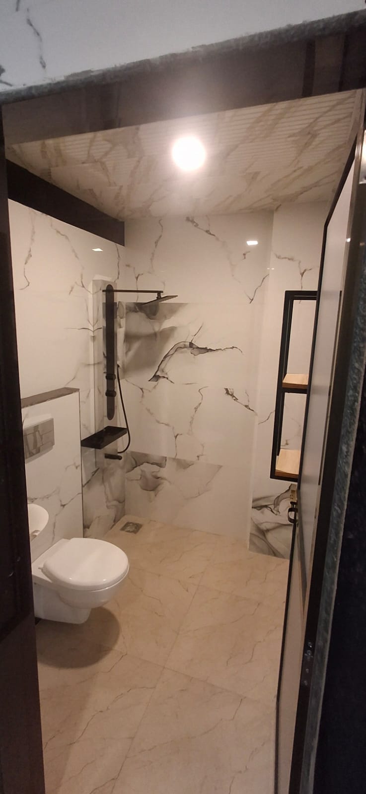 Suite bathroom with rain shower, wash basin and marble-finish walls