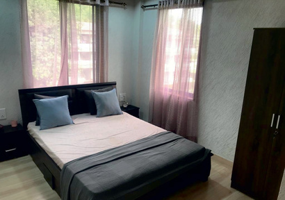 Suite bedroom with queen bed and large windows