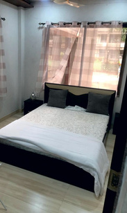 Second suite bedroom with queen bed and curtains